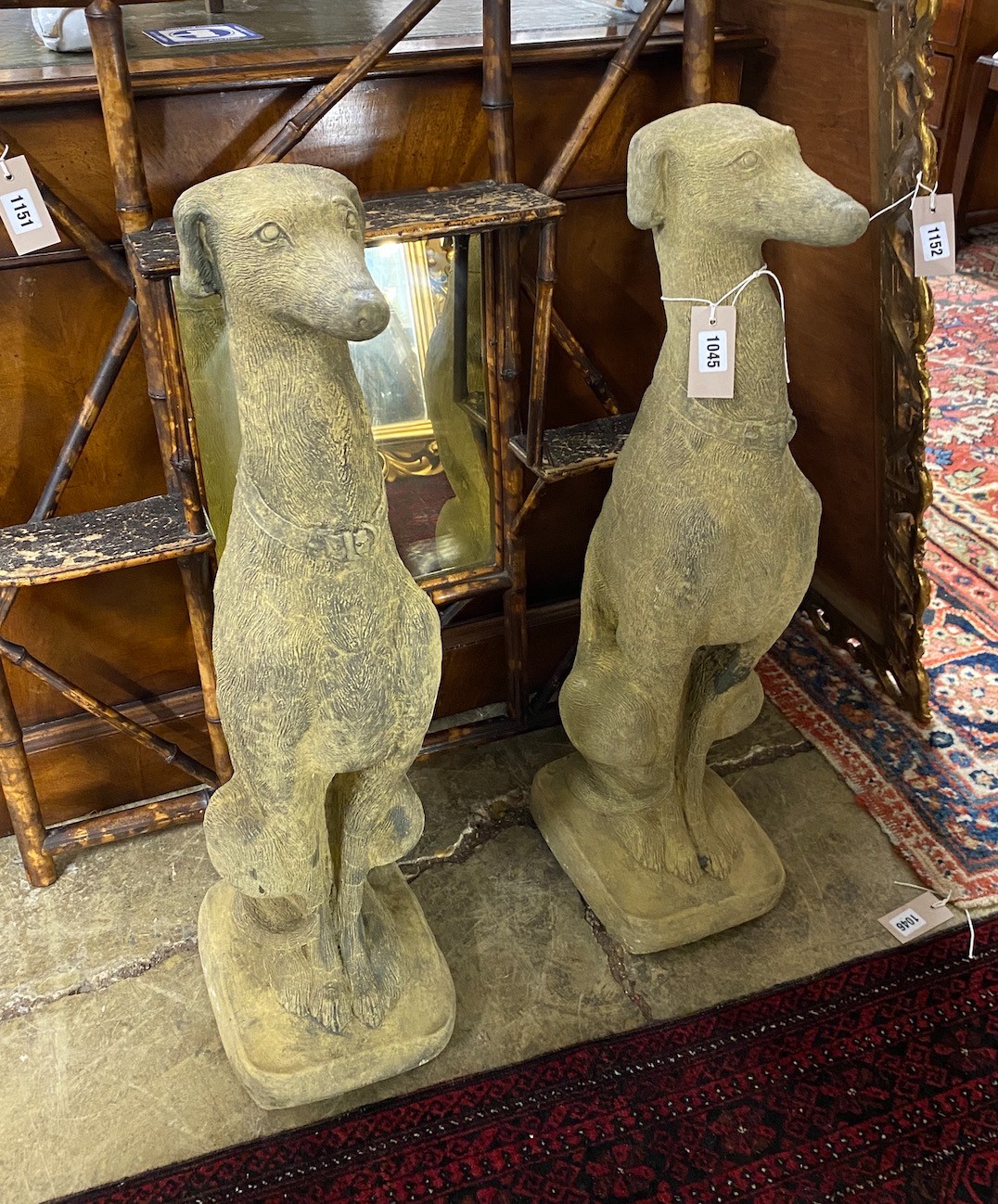 A pair of reconstituted stone seated greyhound garden ornaments, height 74cm
